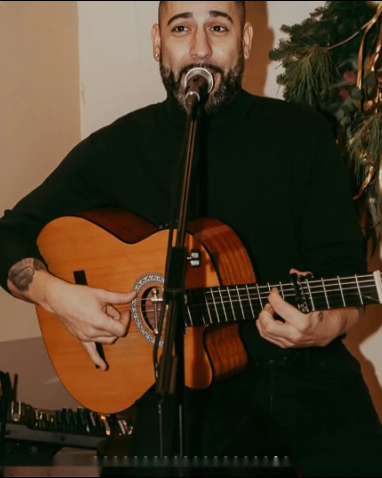 Cantante con guitarra española durante un concierto acústico en Café Tarifa Mairena del Aljarafe